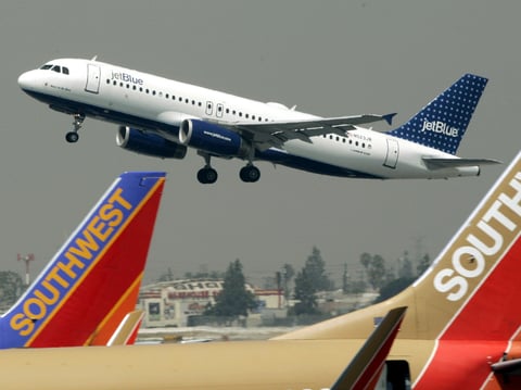 A JetBlue Airbus flies over a pair of Southwest Airlines' jets from Bob Hope Airport in Burbank, Calif., bound for New York's JFK airport, July 19, 2005.