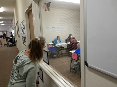 An election observer watches as workers process ballots at the Shasta County Clerk Registrar of Voters office in Redding on Oct. 30, 2024.