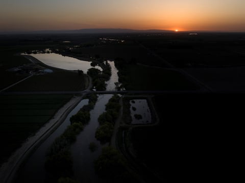 Twilight settles in over the North Fork Kings River in the Island District of Lemoore, Calif., as the sun sets over the horizon on April 19, 2023.