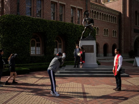 Graduating seniors take photos around the Tommy Trojan statue on the University of Southern California campus in Los Angeles, Thursday, April 25, 2024.