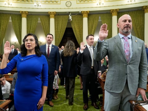 Assembly members Democrat Celeste Rodriguez, left, and Republican Heath Flora, right, join other Assembly members in being sworn-in to office during the assembly's Organizational Session in Sacramento, Calif., Monday, Dec. 2, 2024.