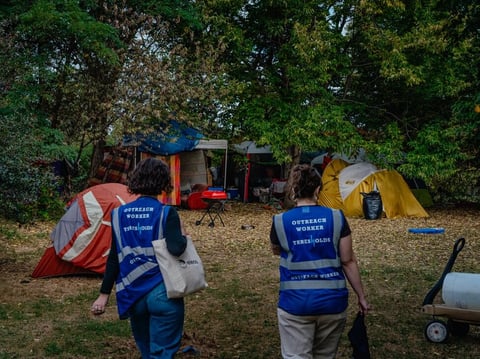 The burst of new laws follows a landmark U.S. Supreme Court ruling and reflects public frustration with record-high homelessness. Outreach workers Lillian Risser (left) and Sophia Loveland approach a tent encampment in Chicago on Sept. 23, 2024.