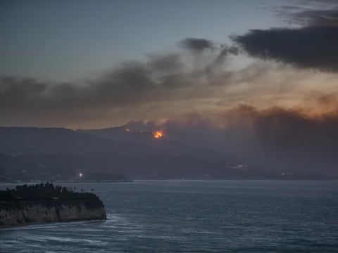 Smoke from the Palisades Fire is seen from Point Dume while it burns homes along the Pacific Coast Highway amid a powerful windstorm on Wednesday in Malibu, California.