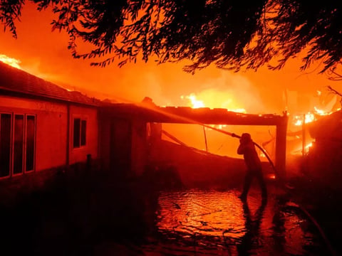 A firefighter douses flames during the Eaton Fire in Pasadena, Calif., on Jan. 8.