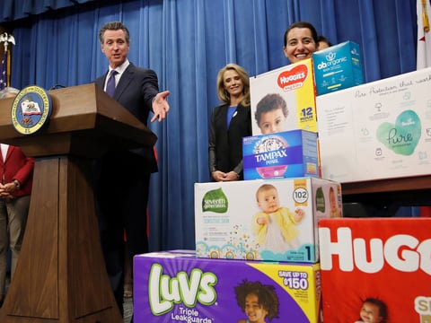 In this May 7, 2019, file photo, Gov. Gavin Newsom gestures towards boxes of tampons and diapers after proposing to eliminate from the state sales tax on such products in his upcoming state budget during a news conference in Sacramento, Calif.