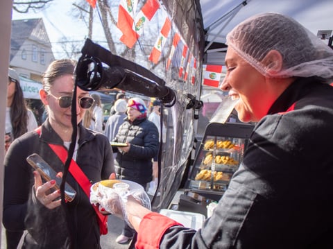 A Mi Estilo Peruvian Delights owner Ada Lisseth Dafne Davis owner hands an empanada to a customer Saturday, Feb. 22, 2025, during the Midtown Farmers Market in Sacramento.
