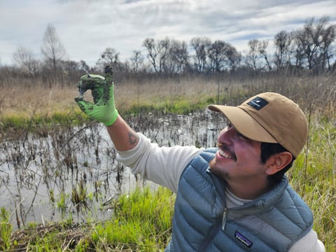 Restoration scientist Diego Garcia holds up a soil sample collected at Dos Rios State Park near Modesto, Feb. 28, 2025.