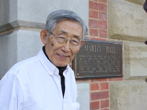 K.W. Lee stands outside of Martin Hall on the West Virginia University campus, where he was a student in the 1950s.