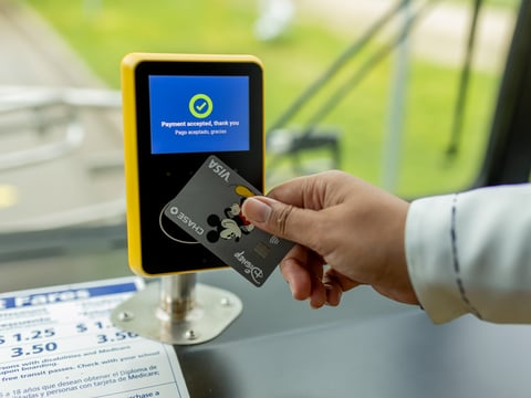 A contactless credit card being used to pay bus fare.
