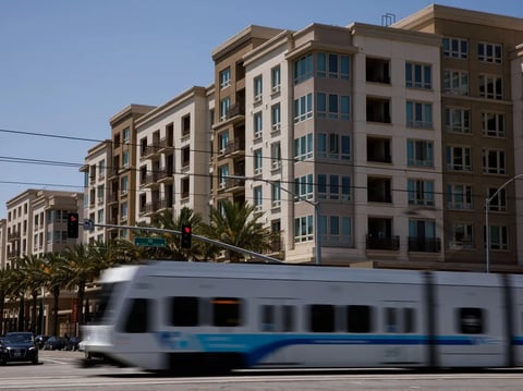 A VTA Light Rail train passes an apartment complex in San Jose on May 10, 2019.