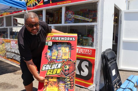 Pastor Levon Davis poses with a box of TNT brand “Safe and Sane” fireworks outside his church’s stand on Fruitridge Road. July 1, 2025.
