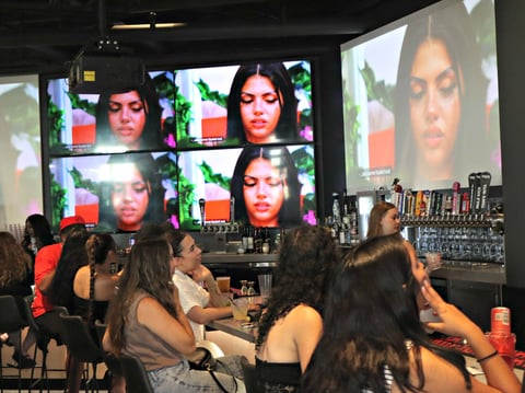 Customers of Tom’s Watch Bar enjoy food and drinks while watching the latest episode of Love Island USA on Thursday.