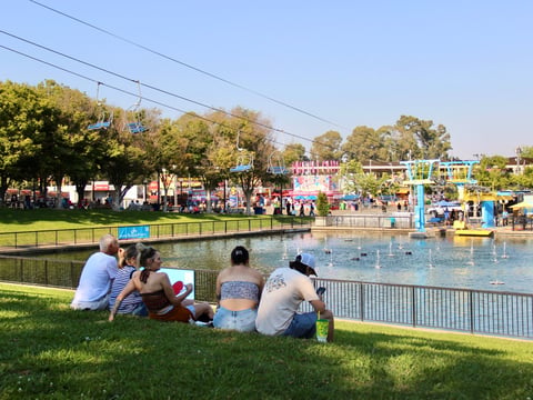 Fairgoers take a break from festivities on the grass steps of the Fountains at Palm Ave during opening weekend of the California State Fair on Friday, July 11 at Cal-Expo in Sacramento.