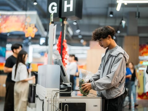 A person uses a self-checkout machine at a store.