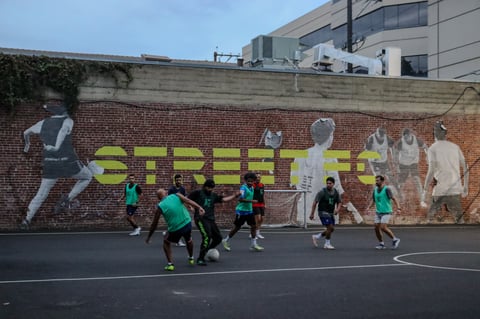 Players compete in a five-on-five futsal match at the Court at 18L, with the Street FC mural visible in the background. Tuesday, Sept. 30, 2025.