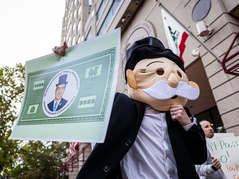 A protester dressed as the Monopoly board game character holds a sign featuring California Attorney General Rob Bonta’s face. Cardroom employees accuse Bonta of favoring large tribal casinos. Oct. 22, 2025.