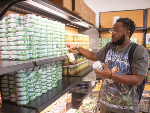 Sacramento State student Tylor Williams grabs several cans of tuna Monday, Oct. 27, 2025, at the campus's food pantry. He's been on CalFresh for two months and said he'll need to rely on pantries like these even more with the government shutdown.