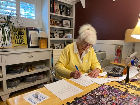 Tee May Duggan writes postcards from her home office in Tahoe Vista urging voters to support Proposition 50. October 5, 2025.