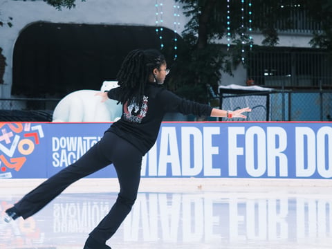 Elijah Bustamante practices her sit spin on the Downtown Sacramento Ice Rink on the corner of 7th and K St on November 12, 2025.