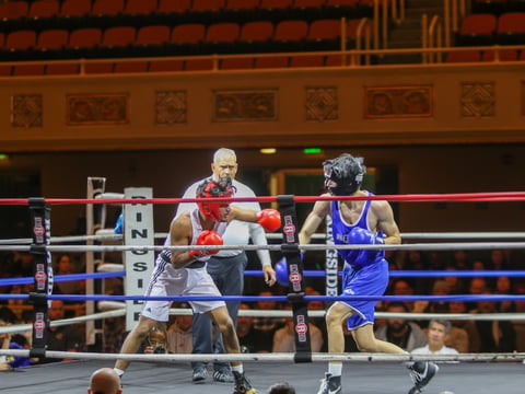 A Sac State boxer (left) vs. a UC Davis boxer (right) throwing combinations at each other at the First Causeway Boxing Classic at the Sacramento Memorial Auditorium Friday, Nov. 22, 2024.
