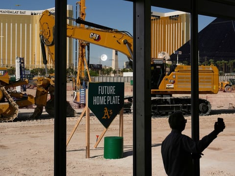 A person takes a picture near construction equipment during a groundbreaking ceremony for the Athletics' baseball stadium Monday, June 23, 2025, in Las Vegas.