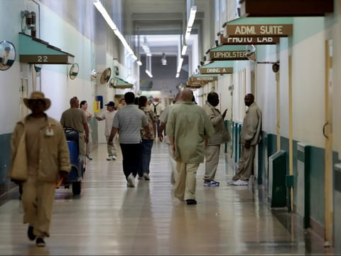 Patients at the Central Coast’s Atascadero State Hospital walk the halls in 2006. Due to COVID, patients have at times been confined to their units, but still mingle in bathrooms, the dining hall and common day rooms.
