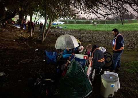 Benjamin Worrall (c) and Eric Guerra, a Sacramento City Council member (r) get information from a woman during the Point-in-Time (PIT) count of people experiencing homelessness Jan. 24, 2024.
