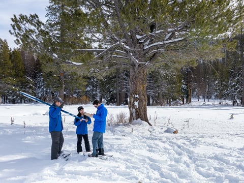 (Left to right) California Department of Water Resources Engineer Anthony Burdock, Hydrometeorologist Angelique Fabbiani-Leon, and Information Officer Jason Ince review data from the first media snow survey of the 2026 season at Phillips Station.