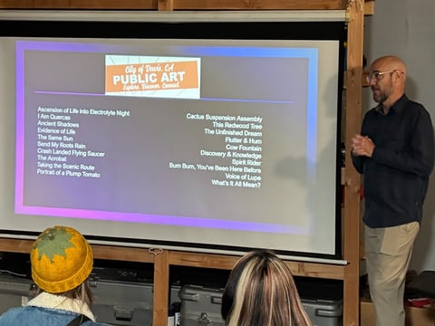 Organizer Craig Musburger revealing the mystery prompt filmmakers must follow at a reveal event for the Davis Flash Film Festival.