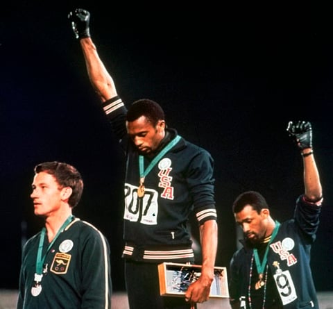 FILE - In this Oct. 16, 1968, file photo, Australian silver medalist Peter Norman, left, stands on the podium as Americans Tommie Smith, center, and John Carlos raise their gloved fists in a human rights protest.