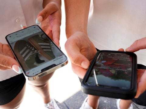 FILE - Young people use their phones to view social media in Sydney, Nov. 8, 2024.