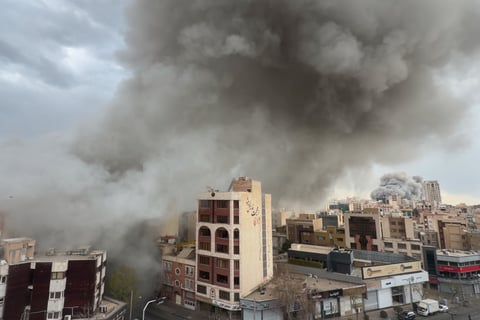 Plumes of smoke from two simultaneous strikes rise over Tehran, Iran, Monday, March 2, 2026. (AP Photo/Mohsen Ganji)