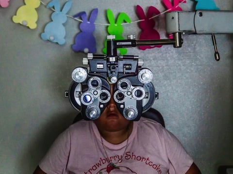 Mia Ochoa, 9, behind a Phoropter during an eye exam at Vision to Learn mobile optometry clinic at Esther Lindstrom Elementary School in Lakewood on March 20, 2026.
