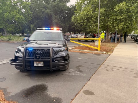 Parents and law enforcement gather outside Natomas High School in Sacramento on April 10, 2026, after a shooting on campus. A 16-year-old was killed and police launched a search for a suspect.