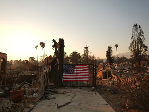 FILE - An American flag hangs on the gate of a home destroyed by the Eaton Fire in Altadena, Calif., Jan. 10, 2025.