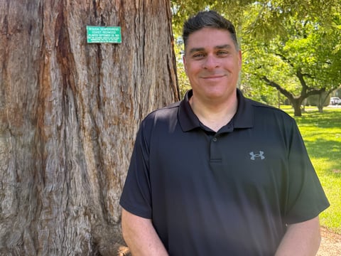 Michael Nielson is the grounds operation manager for the Department of General Services. He's stands next to his favorite tree on Thursday April 16, 2026.