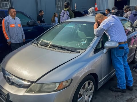 People inspect a vehicle at an auction at Bruffy's Tow in Marina Del Rey on Feb. 18, 2025.
