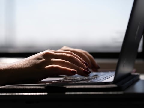 FILE - This May 18, 2021, photo shows a woman typing on a laptop on a train in New Jersey.
