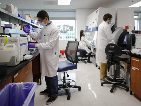 From left, Sergio Vazquez, Dinah Amante, and Alex Dolgoter work in a lab at Inovio Pharmaceuticals, a biotech company in San Diego, on June 4, 2020.