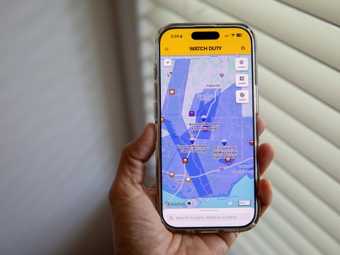 A person uses the Watch Duty app to track floods, Thursday, June 18, 2026, in San Diego, Calif.