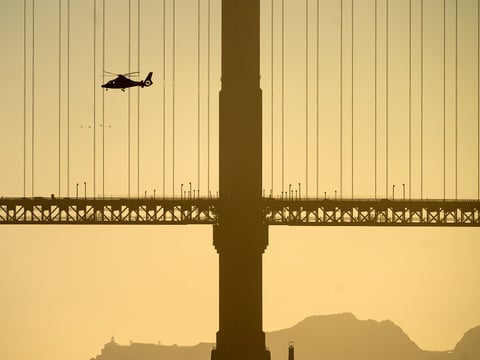 A helicopter flies past the Golden Gate Bridge while searching for missing victims after a boat accident near Alcatraz Island off San Francisco, Tuesday, July 14, 2026.