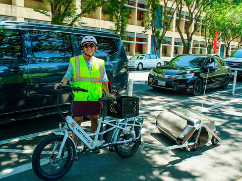 Sacramento Area Bike Advocates Policy and Advocacy Director Deb Banks stands with Crunch, the bike lane cleaner on July 16, 2026.