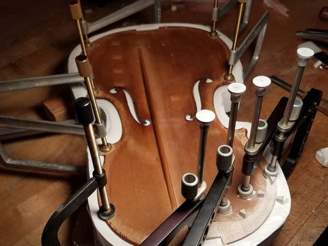 The Totenberg-Ames Stradivarius is pictured in a mold while being prepared to have its edge reinforced during restoration.