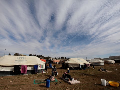 Refugees take a rest outside their tents at an unofficial refugee camp on the outskirts of Amman, Jordan, Wednesday, Jan. 22, 2014.