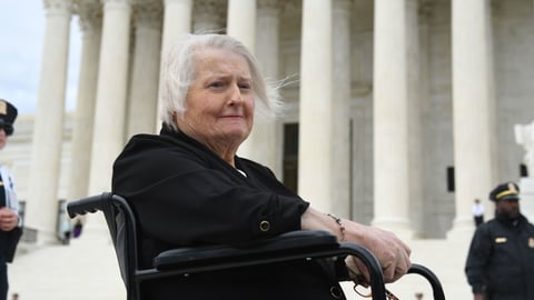 Transgender activist Aimee Stephens sits in her wheelchair outside the Supreme Court on Oct. 8, 2019, as the court holds oral arguments in cases dealing with workplace discrimination based on sexual orientation.