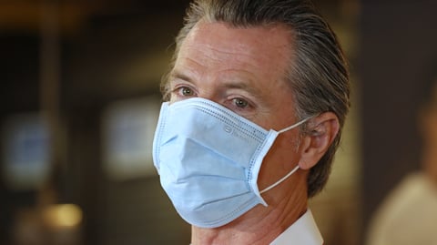 California Gov. Gavin Newsom, here in Sacramento on Friday, has ordered face coverings be required in public spaces statewide.