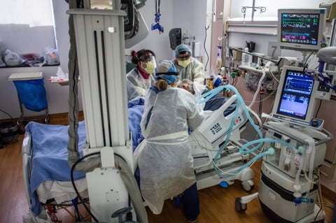 Physicians and nurses wear personal protective equipment while they attend to a COVID-19 patient in the ICU at Providence Cedars-Sinai Tarzana Medical Center in Tarzana, Calif. on December 18, 2020.