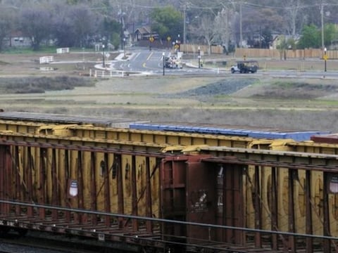 Rail cars sit on the tracks adjacent to Curtis Park Village. 