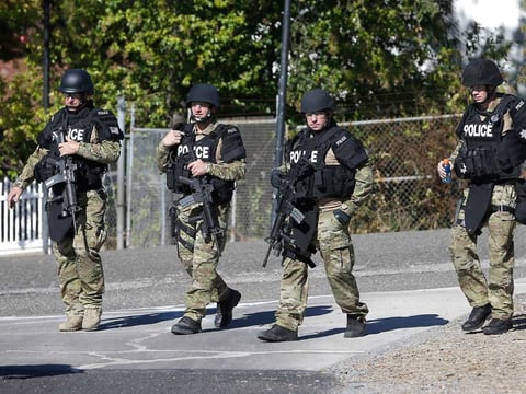 Law enforcement officers dressed in tactical gear leave the Gold County Fairgrounds to help in the search of an assailant, in Auburn, who shot three sheriff's deputies and one civilian, killing two, in Sacramento and Placer counties on Oct. 24, 2014