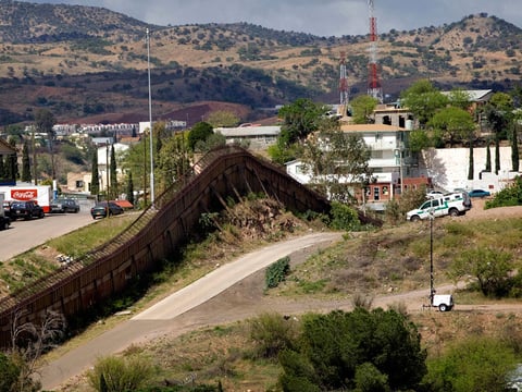 A Custom and Border Patrol agent watches the international border in Nogales, Ariz. Thursday, April 22, 2010.